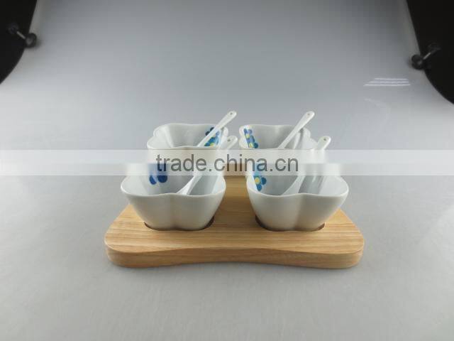 white porcelain clover-shaped dish set with spoon and wood tray