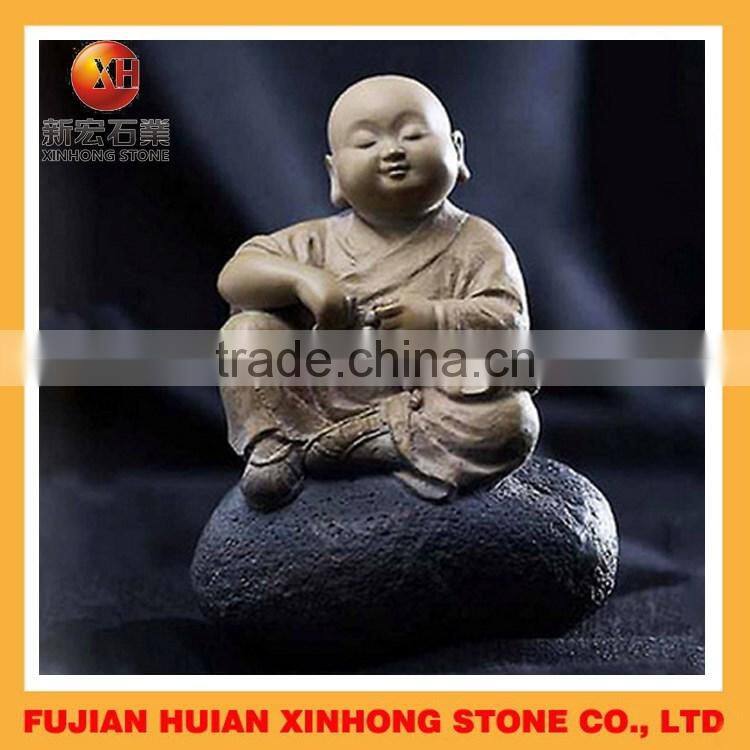 lava stone little monk sitting on the stone for garden decoration