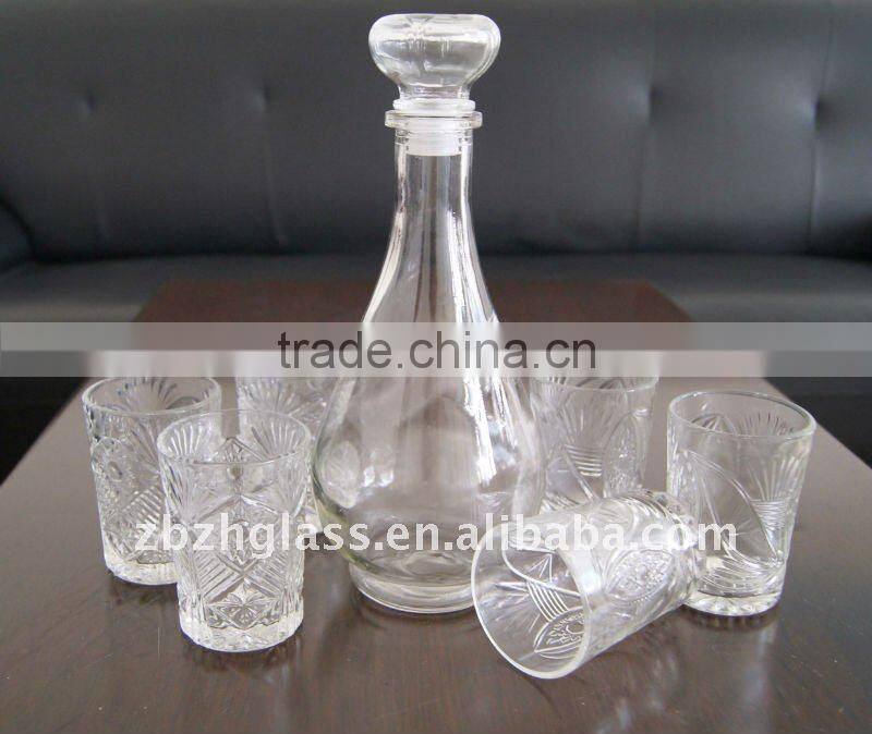 round clear glass wine bottle and cups