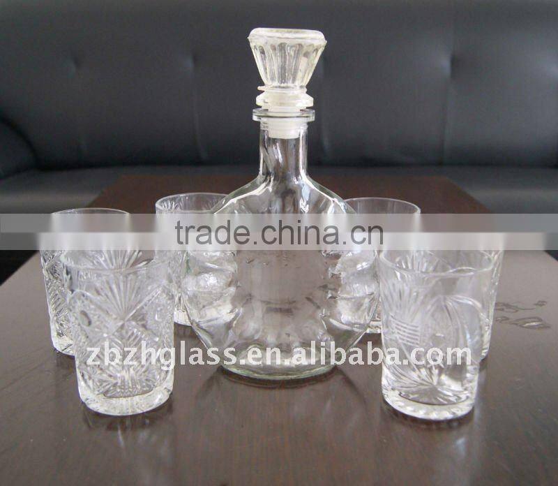 round clear glass wine bottle and cups
