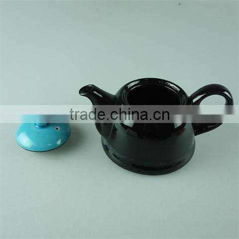 Glazed black teapot with blue cover in stock