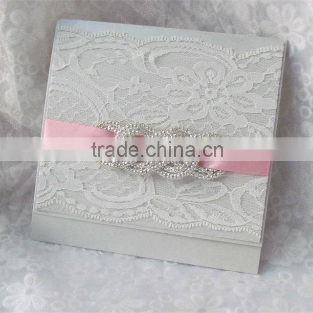 Attractive white lace wedding invitation cards with pink ribbons and brooches