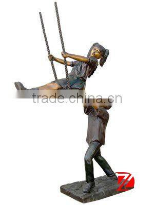large boy and girl sculpture play on a swing