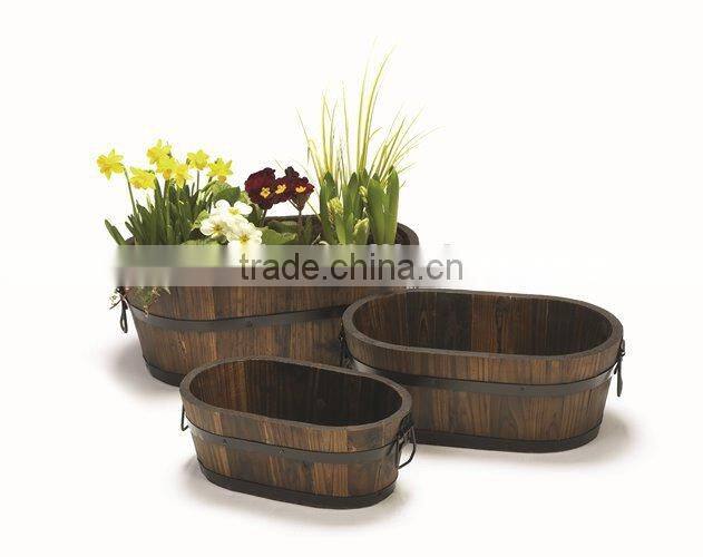 3-Ovals Burntwood flower barrels in garden