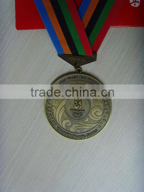 Golden badge/lapel pin/medal with green ribbon