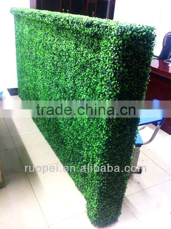 Vertical artificial plastic green wall and hanging decorations