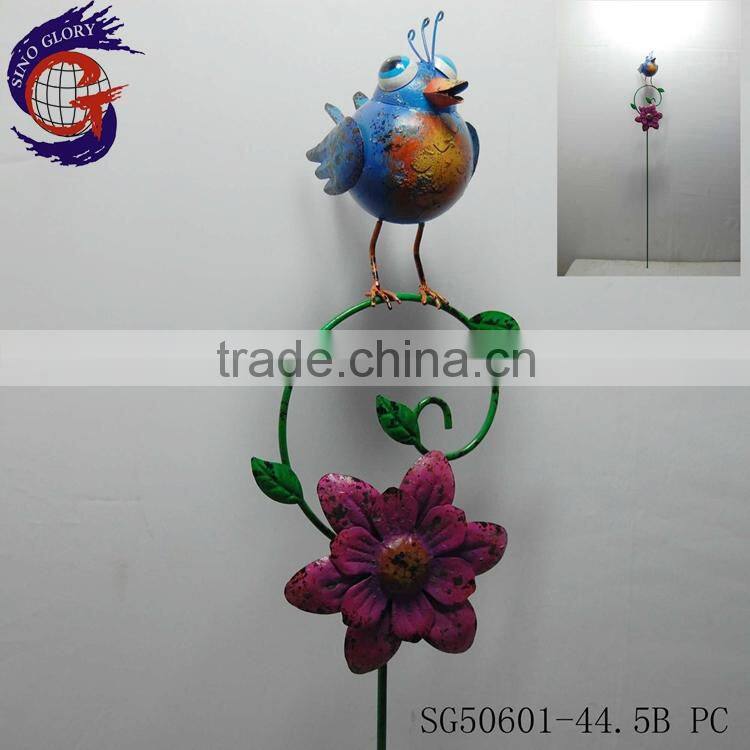 Antique birds stand on stakes with metal garden decoration windmill