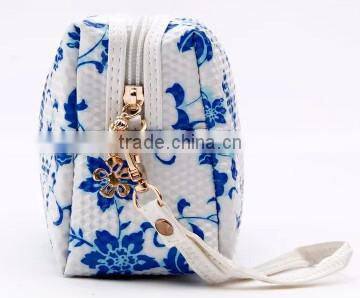 Blue and white diamond pattern cosmetic bag in hand