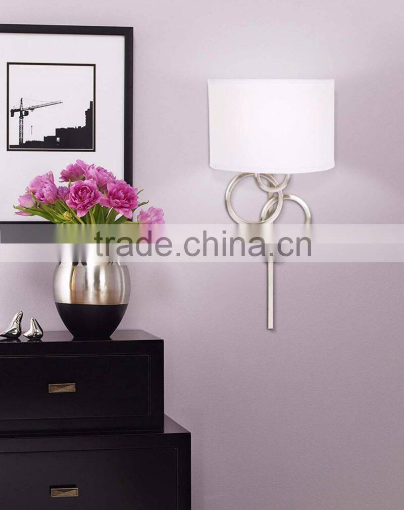 1017-1 sleek brushed steel finish raindrops falling on a calm body of water intertwining Circles Plug-In Wall Sconce