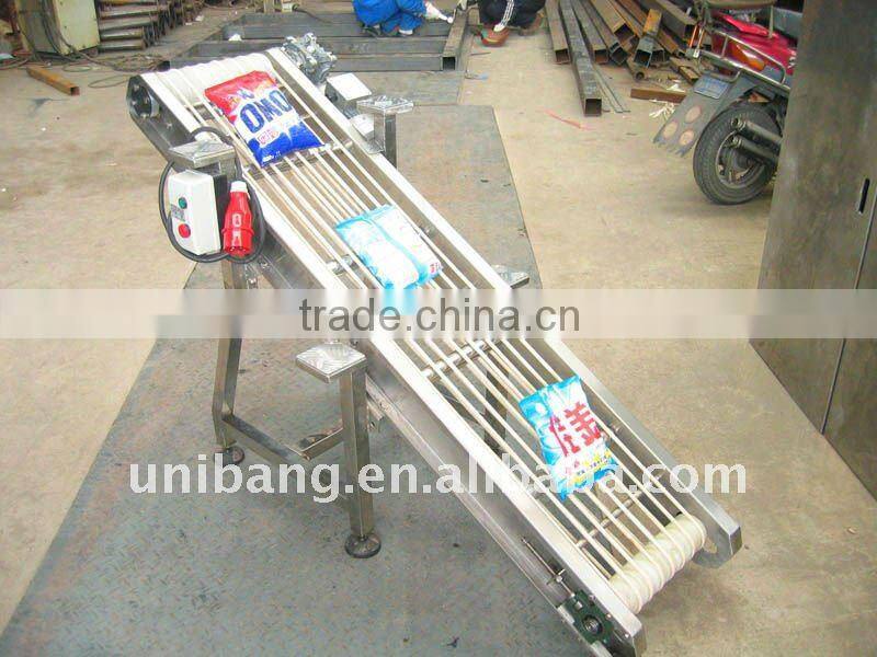 Feed out packing conveyor for packing machine