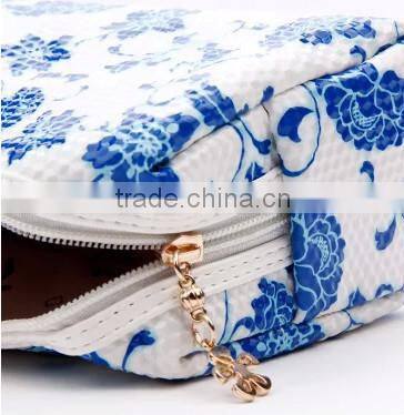 Blue and white diamond pattern cosmetic bag in hand