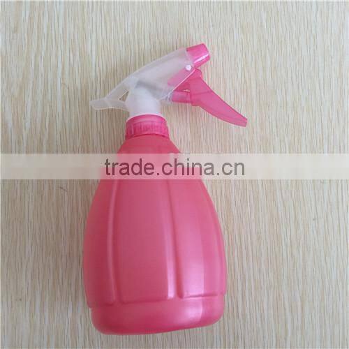 pink plastic garden spray bottle with trigger