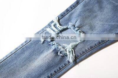 Slightly faded blue jeans with zip down whiskering ripped pants