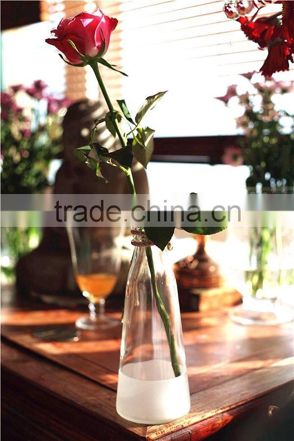 white and transparent glass vase with rope decoration and artificial flower