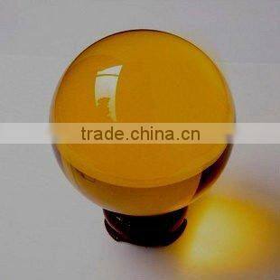 Amber color crystal ball with wooden base
