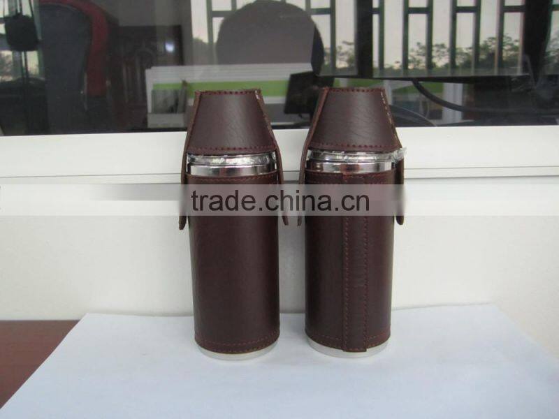Cylindrical shape and suture and leather wrapped bottle and 2 glasses