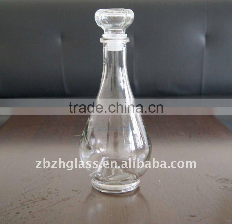 round clear glass wine bottle and cups