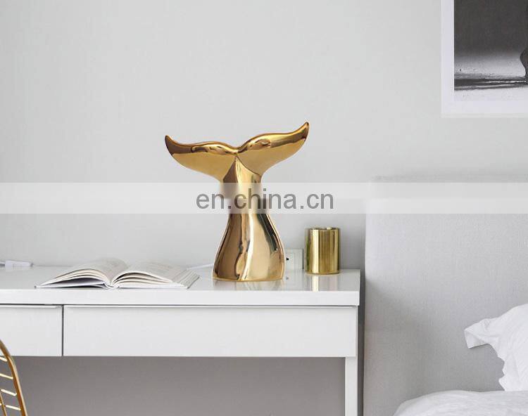 ceramic artwork of golden whale tail ornaments