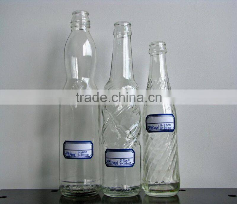 clear glass carbonated beverage bottle
