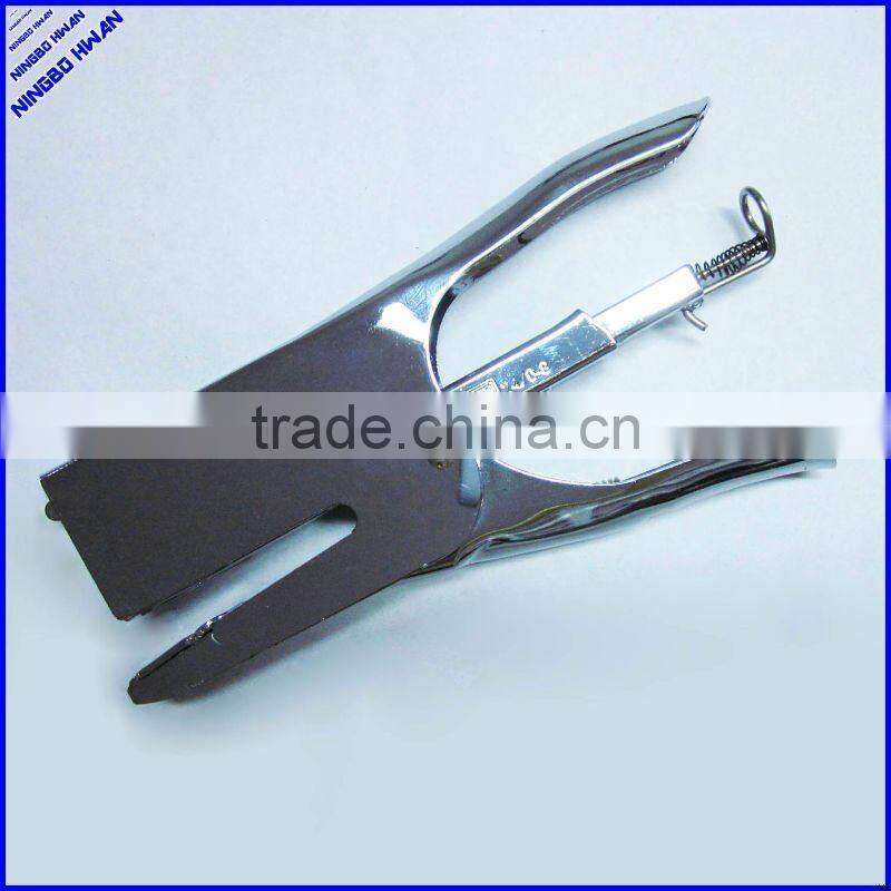 Las manos de alicate metal engrapadora