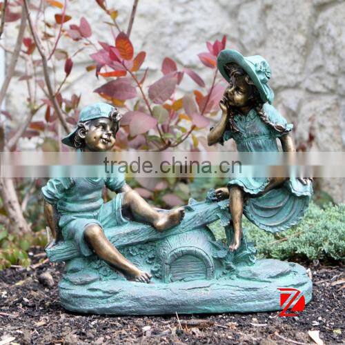 Garden playing boy and girl sculptures with teeterboard
