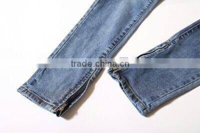 Slightly faded blue jeans with zip down whiskering ripped pants