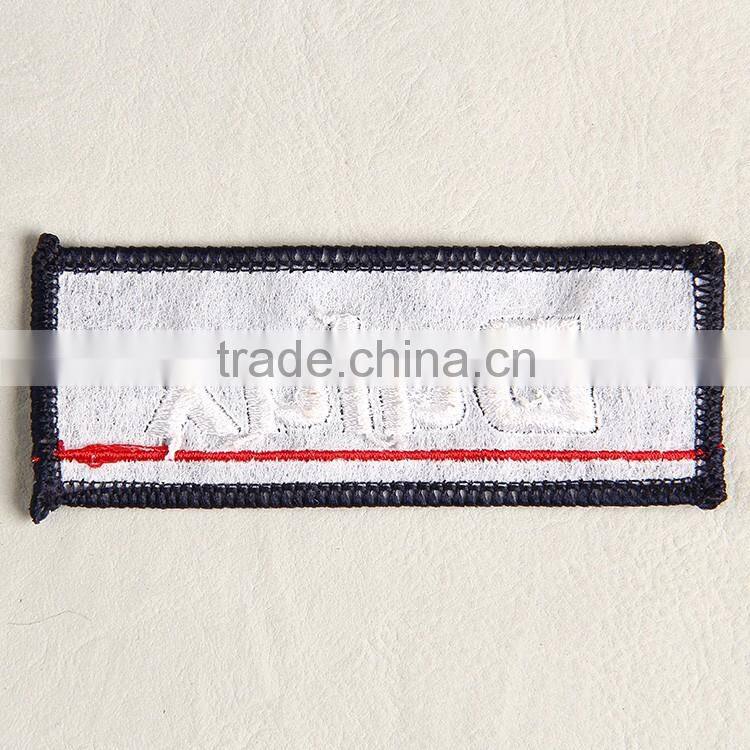 Damask woven label with overlocked embroidery for girls' bell bottom pants