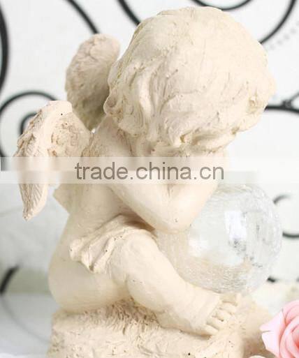 Resin solar lighting angle figurine holding a luminur glass globe garden ornamenet