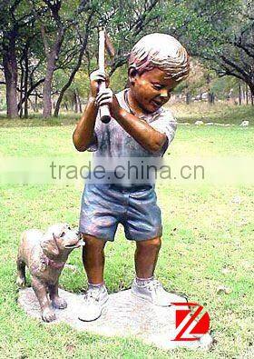 Bronze baseball boy statue with a dog in garden