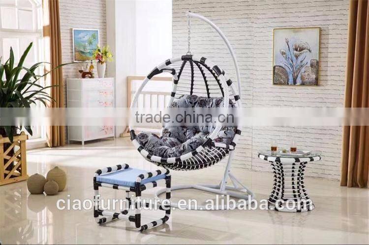 Round Wicker Hanging Chair In Room With Ottoman