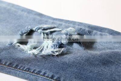 Slightly faded blue jeans with zip down whiskering ripped pants