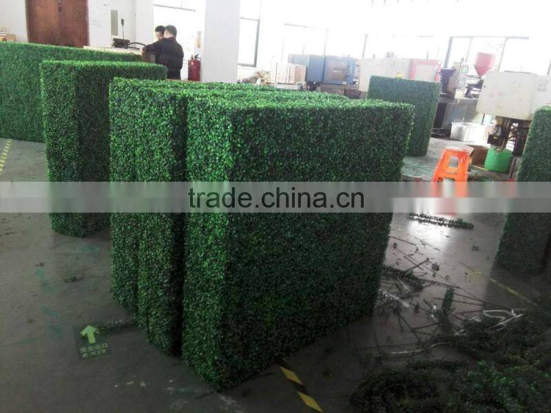 Vertical artificial plastic green wall and hanging decorations