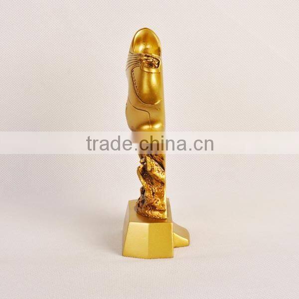 Gold football shoe with figure trophy