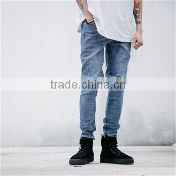 Slightly faded blue jeans with zip down whiskering ripped pants