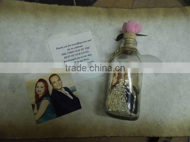custom made glass bottle wedding invitations with custom printed names of guests made with blue sands and shells, wedding invite