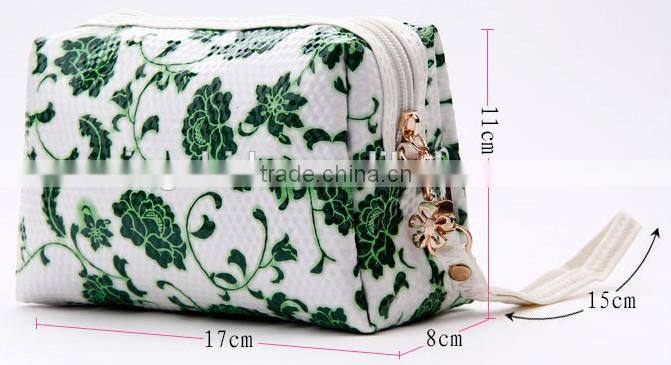 Blue and white diamond pattern cosmetic bag in hand