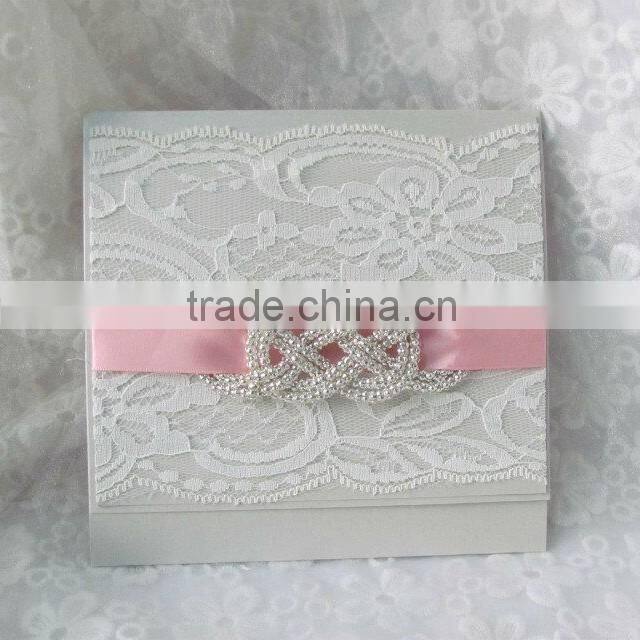 Attractive white lace wedding invitation cards with pink ribbons and brooches