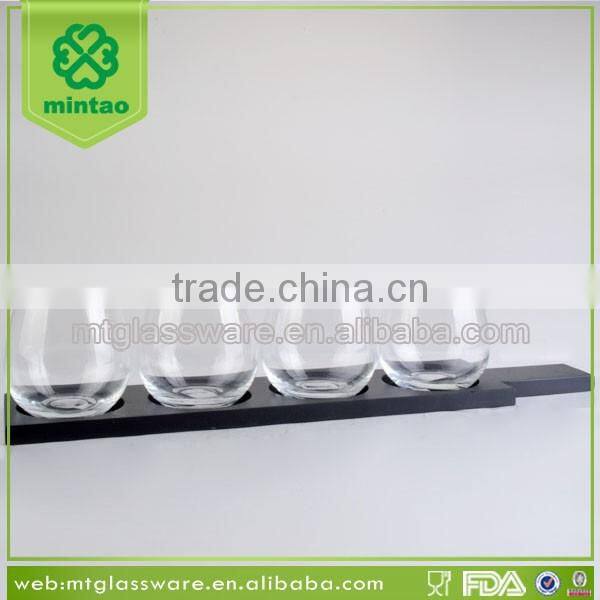 Clear stemless wine glass beer cup with black wooden rack and plate