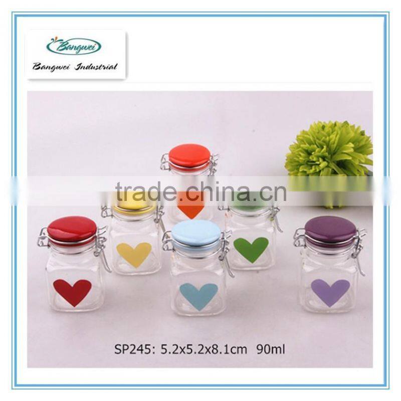 square glass jar with colorful ceramic lid and heart design