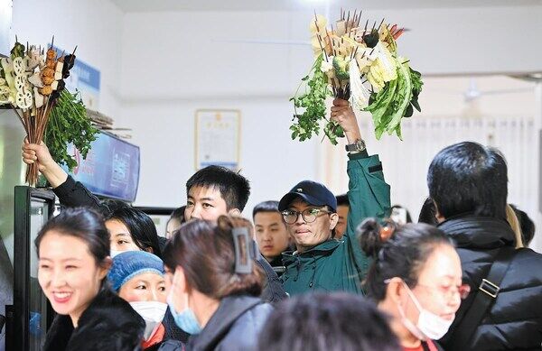 Customers hold on to their chosen ingredients at a crowded malatang restaurant in Tianshui, Gansu province, on Thursday. JIGME TENZIN / CHINA NEWS SERVICE