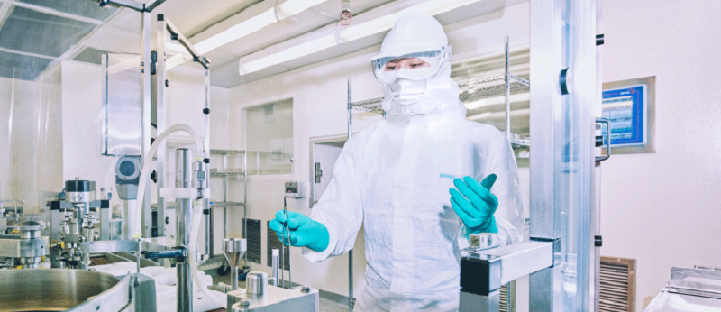 Worker in a lab setting with protective clothing.png