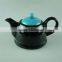 Glazed black teapot with blue cover in stock
