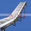 Incline belt conveyor with hopper and discharge chute
