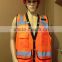 Orange high visibility safety vest with many pockets