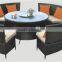 Round based well used patio stacking furniture in top restaurant table and wicker chairs