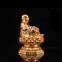 The golden happy buddha stuatue is seated in a double lotus base show his smiling and big belly