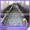 Abrasion resistant rubber conveyor belt with full guage skims between plies