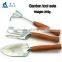 Green product hand holding wooden handle garden tool set