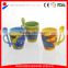 coloured ceramic coffee mug with design printing and spoon in handle