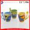 coloured ceramic coffee mug with design printing and spoon in handle